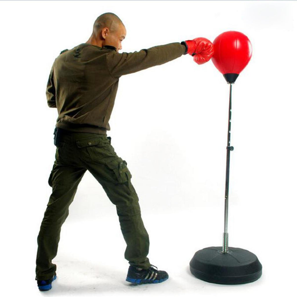 self defense instructor wearing boxing gloves striking free standing red inflatable punching bag with black base